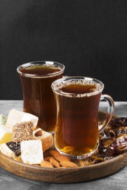 Siyah çay, oryantal tatlılar, tarihleri ve karanlık bir arka plan üzerinde fındık