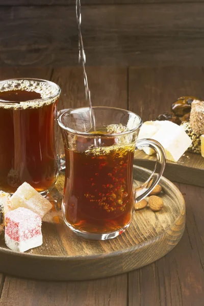Siyah çay, oryantal tatlılar, tarihleri ve koyu ahşap arka fındık