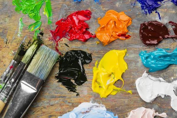 Çeşitli sanat yağlı boya bir ahşap palet ve bir fırça. Üstten Görünüm