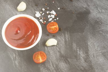 Beyaz kase, baharat ve karanlık bir arka plan üzerinde domates domates sosu. Uzay kopyalayın. Gıda arka plan. Tonlama.