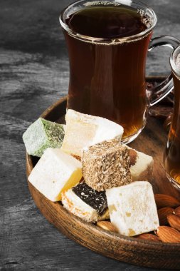 Siyah çay, oryantal tatlılar, tarihleri ve karanlık bir arka plan üzerinde fındık. Tonlama.