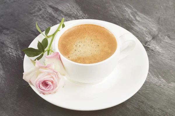 Espresso coffee in a white cup and a pink rose on a dark background. Toning. — Stock Photo, Image
