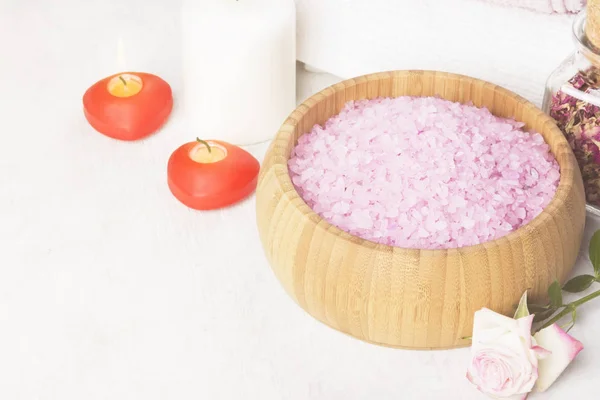 Sal de baño con aroma a rosa en un cuenco de madera, pétalos y rosa fresca, toallas y velas sobre fondo blanco. Copiar espacio. Tonificación . — Foto de Stock