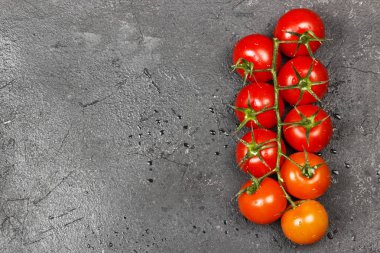 Karanlık bir arka plan üzerinde (kırmızı portakal degrade) dal kiraz domates. Görünümü en çok, uzay kopyalayın. Gıda arka plan