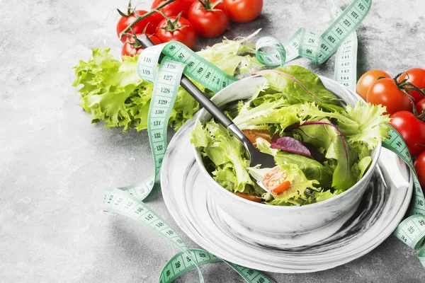 La ensalada dietética mixta de verduras (mesclun, mache, lechuga) y los tomates cherry en un bol sobre un fondo claro. Copiar espacio. Fondo alimentario — Foto de Stock