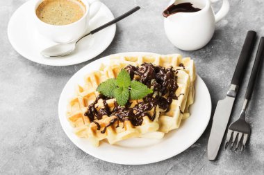 Beyaz çikolata ve nane, kahve plakalı, sos-tekne ile hafif bir arka plan üzerinde çikolata gözleme