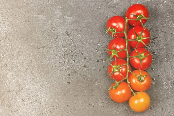 Karanlık bir arka plan üzerinde (kırmızı portakal degrade) dal kiraz domates. Görünümü en çok, uzay kopyalayın. Gıda arka plan. Tonlama