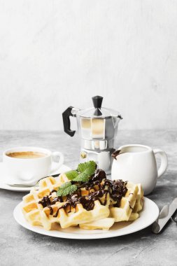 Beyaz çikolata ve nane, kahve plakalı, sos-tekne ile hafif bir arka plan üzerinde çikolata gözleme