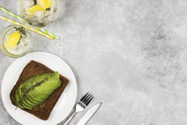 Odaya Servis Kahvaltı - çavdar ekmeği ile avokado, hafif bir arka plan üzerinde limonata içelim. Görünümü en çok, uzay kopyalayın. Gıda arka plan