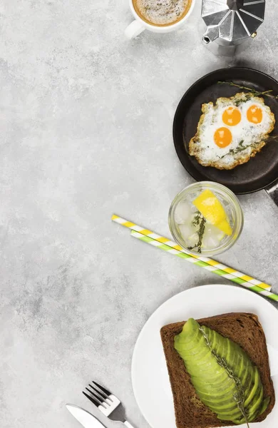 전통적인 아침 식사-토스트와 아보카도, 메 추 라 기 계란에서 튀긴된 계란, 밝은 배경에 레모네이드 호 밀 빵에서. 보기 상위, 공간을 복사 합니다. 음식 배경 — 스톡 사진