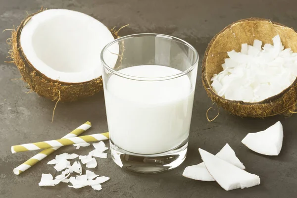 Vegan coconut milk in glass on a dark background. Non-dairy milk