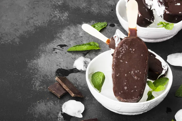 Vaniljglass på pinne täckt med choklad glasyr på en dar — Stockfoto