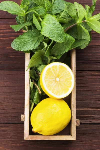 Los ingredientes para la limonada - el limón, la menta en la caja de madera sobre la madera — Foto de Stock