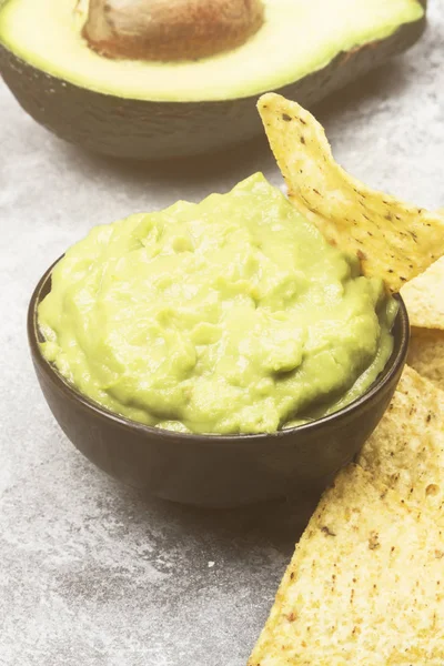 Molho latino-americano tradicional guacamole em uma tigela e nachos . — Fotografia de Stock