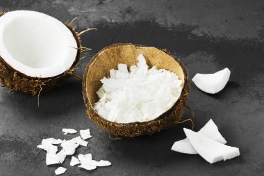 Yarısı olgun hindistan cevizi ve Hindistan cevizi talaşı karanlık bir arka plan üzerinde