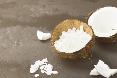 Olgun Hindistan cevizi ve Hindistan cevizi talaşı karanlık bir arka plan üzerinde yarısı. Uzay kopyalayın. Gıda arka plan. Tonin