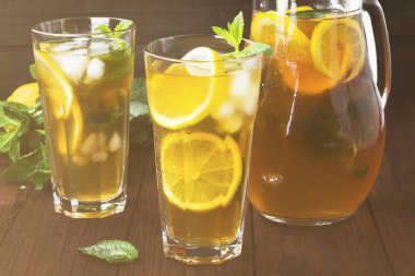 Buzlu çay limon ve nane bir ahşap zemin üzerinde. Tonlama