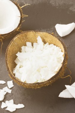 Olgun Hindistan cevizi ve Hindistan cevizi talaşı karanlık bir arka plan üzerinde yarısı. Tonlama