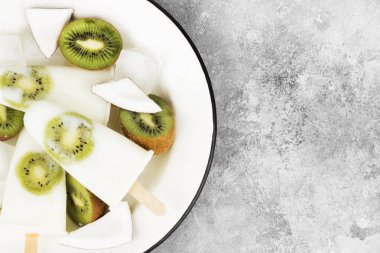 Yoğurt dondurma / Hindistan cevizi Süt kivi hafif bir arka plan üzerinde üzerinden. Görünümü en çok, uzay kopyalayın. Gıda arka plan