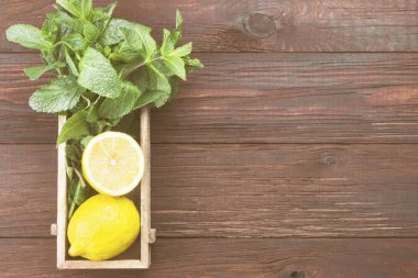 Ahşap arka plan üzerinde ahşap kutusunda limonata - limon, nane için malzemeler. Görünümü en çok, uzay kopyalayın. Gıda arka plan. Tonlama