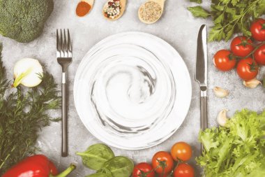 Kavram diyet ve sebze gıda. Plaka mermer desenleri ile. Çeşitli sebze ve baharat (brokoli, biber, domates, sarımsak, marul, maydanoz, rezene) hafif bir arka plan üzerinde. Görünümü en çok, uzay kopyalayın. Gıda arka plan. Tonlama