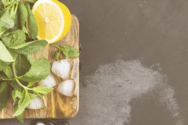 Limonata - limon, nane, için malzemeler ahşap kesme tahtası koyu arka plan üzerinde buz. Görünümü en çok, uzay kopyalayın. Gıda arka plan. Tonlama