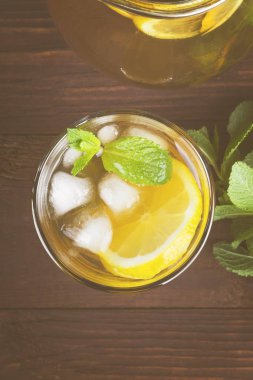 Buzlu çay limon ve nane bir ahşap zemin üzerinde. Üstten Görünüm. Gıda arka plan. Tonlama
