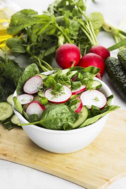 Turp, salatalık ve hafif bir adam üzerinde ıspanak salatası