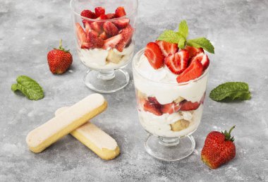 Tatlı tiramisu çilek üzerinde gri bir arka plan ile