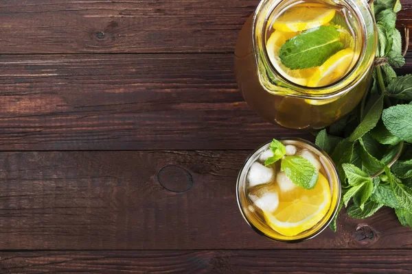 Ice tea with lemon and mint on a wooden background. Top view, co — Stock Photo, Image