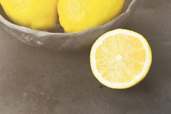 Лимоны в глиняной миске на темном фоне. Тонирование — стоковое фото