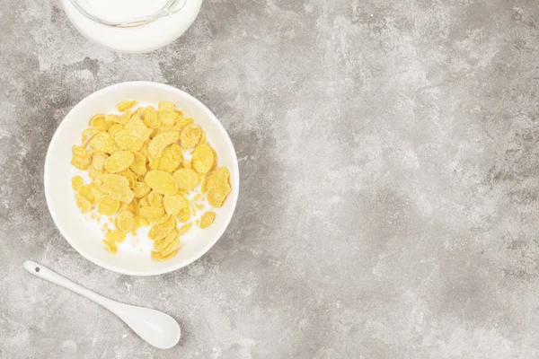 Taza de copos de maíz con leche sobre un fondo claro. Vista superior, espacio de copia. Fondo alimenticio. Tonificación — Foto de Stock