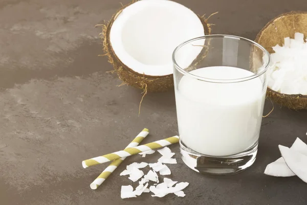 Vegan coconut milk in glass on a dark background. Non-dairy milk. Copy space. Food background. Toning