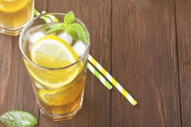 Buzlu çay limon ve nane bir ahşap zemin üzerinde. Uzay kopyalayın. Gıda arka plan. Tonlama