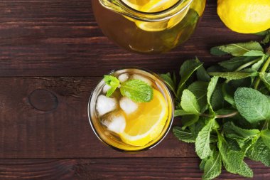 Buzlu çay limon ve nane bir ahşap zemin üzerinde. Üstten Görünüm. Gıda arka plan