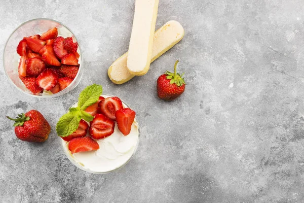 Dessert-Tiramisu mit Erdbeere auf grauem Hintergrund. Ansicht von oben, Kopierraum. Lebensmittel-Hintergrund — Stockfoto