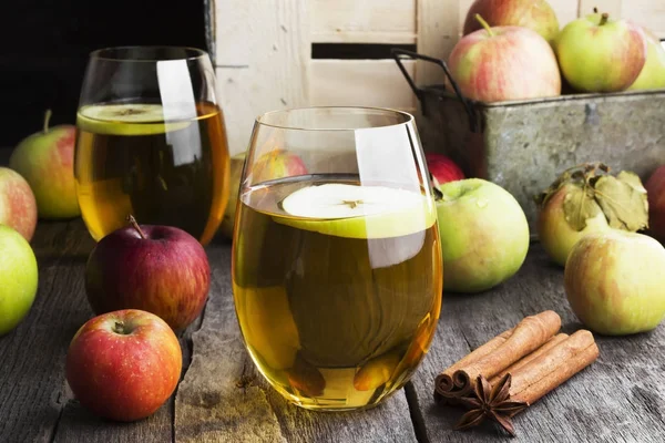 Яблочный сок в стакане с каемоном и анисом на темном дереве — стоковое фото