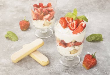 Tatlı tiramisu çilek üzerinde gri bir arka plan ile. Tonlama