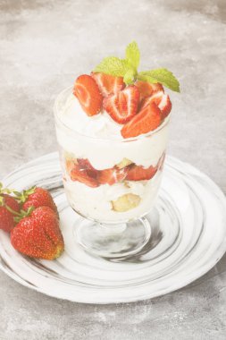 Tatlı tiramisu çilek üzerinde gri bir arka plan ile. Tonlama