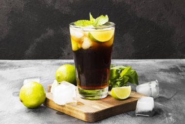 Bir bardak koyu arka plan üzerinde kokteyl Cuba Libre. Kopya alanı.