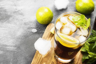 Bir bardak koyu arka plan üzerinde kokteyl Cuba Libre. Kopya alanı.