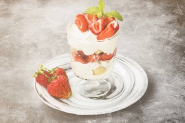 Tatlı tiramisu çilek üzerinde gri bir arka plan ile. Tonlama