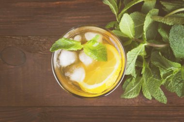 Buzlu çay limon ve nane bir ahşap zemin üzerinde. Üstten Görünüm. Fo