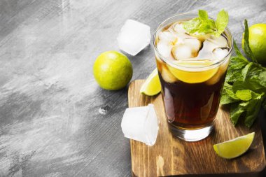 Bir bardak koyu arka plan üzerinde kokteyl Cuba Libre. Kopya alanı.