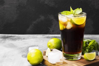 Bir bardak koyu arka plan üzerinde kokteyl Cuba Libre. Kopya alanı.