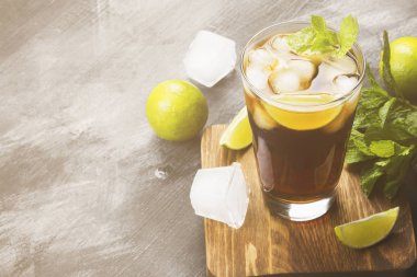 Bir bardak koyu arka plan üzerinde kokteyl Cuba Libre. Kopya alanı.