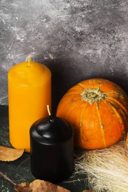 Olgun pumpkins, yeşil bir arka plan üzerinde turuncu ve siyah mum