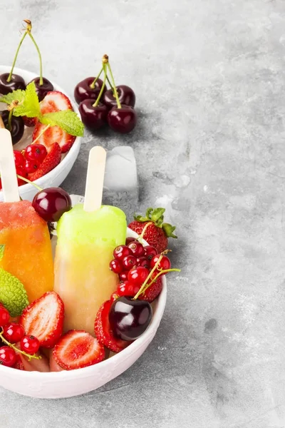 Mehrfarbige Eis am Stiel mit Erdbeere, roter Johannisbeere und Kirsche — Stockfoto