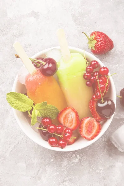 Mehrfarbige Eis am Stiel mit Erdbeere, roter Johannisbeere und Kirsche — Stockfoto