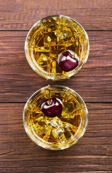 Kokteyl kiraz ahşap arka iki gözlük ile viski üzerinden